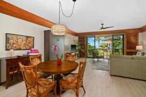 a living room with a table and chairs and a couch at Top Floor Ocean View Condo at Poipu Kapili- Alekona Kauai in Koloa