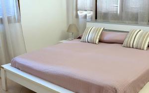 a bedroom with a bed with pink sheets and a lamp at Casa Carla in Peschiera del Garda
