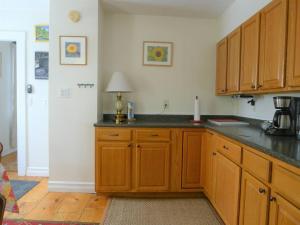 a kitchen with wooden cabinets and a black counter top at Discover Downeast Maine - Comfortable Home Base 37 in Ellsworth