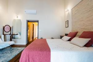 ein Schlafzimmer mit einem großen Bett mit einer rosa Decke in der Unterkunft Casa del Estanco, casa rural in Salteras