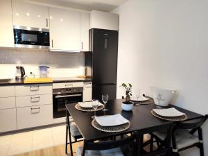 a kitchen with a table with chairs and a black refrigerator at Tu casa a 10 minutos de París! in Bagneux +13 photos