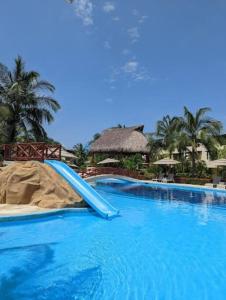 un toboggan bleu au milieu d'une piscine dans l'établissement Villa Sol Terrasol Acapulco Diamante, à Acapulco