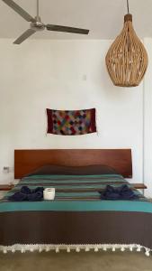 1 cama en un dormitorio con ventilador de techo en Dada, en Brisas de Zicatela
