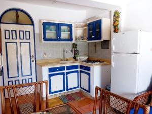 a kitchen with blue cabinets and a white refrigerator at El Castillo Dominicus in La Laguna