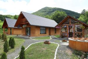 a log cabin in the mountains with a yard at Cabana Izvorul Rece Maramureş in Baia-Sprie