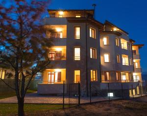 a large white building with its lights on at Family Hotel Relaxa in Sapareva Banya