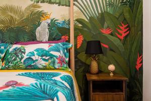 Un dormitorio con una cama con papel pintado tropical. en Artistic flat next to Ruzafa Welcome to the Jungle, en Valencia