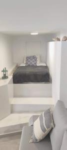 a white bedroom with a bed and a couch at Studio18 in Márpissa