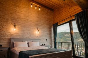 a bedroom with a bed and a large window at Cabana Delena in Vatra Dornei