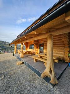 a log cabin with wooden posts and a roof at Cabana Delena in Vatra Dornei +13 photos