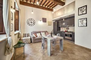 a kitchen and living room with a table and a couch at La Casa di Nonna Danda in Montepulciano