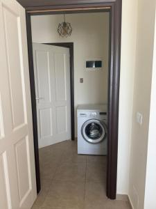 a laundry room with a washing machine and a door at Todhe Apartment - Gjiri Lalezit 500m from the beach in Draç