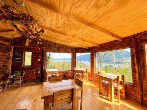 a room with a table and chairs in a cabin at Patagonia Nativa in Cochamó