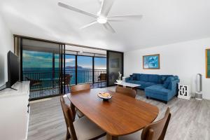 a living room with a table and a blue couch at Kona Alii 602 in Kailua-Kona