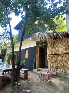 a house with a bench and a table and a tree at Casa de las brujas hostal in Zipolite +24 photos