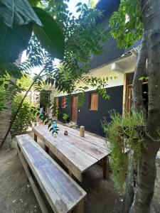 a wooden picnic table in front of a house at Casa de las brujas hostal in Zipolite