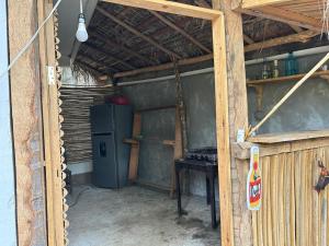a kitchen with a refrigerator and a table in a room at Casa de las brujas hostal in Zipolite