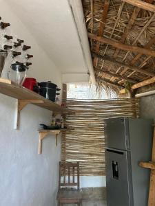 a kitchen with a refrigerator and a chair in it at Casa de las brujas hostal in Zipolite