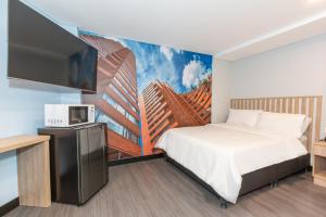 a hotel room with a bed and a tv at Terrazas in Bogotá