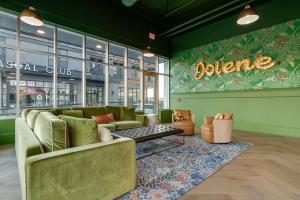 a living room with green furniture and a sign that reads blaine at Jolene on Main - East Nash - 1 Mile to DTNash - NEW in Nashville