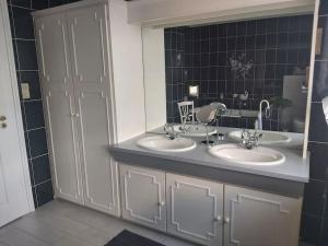 un bagno con due lavandini e un grande specchio di Chez Jeanine Maison Familiale a Schaeffersheim Altre 17 foto