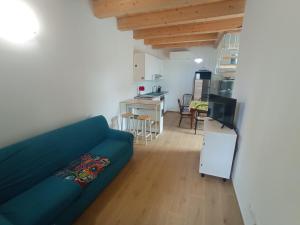 a living room with a blue couch and a kitchen at Da Zia Vecchia in Cervia