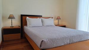 a bedroom with a bed with two lamps on tables at Hills and Atlantic Ocean retreat - Conceição House in Calheta