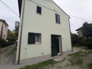 a white building with green shutters on it at Da Zia Vecchia in Cervia