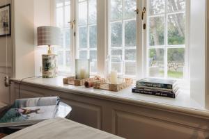 a table with books and candles and a window at Watt Perle in Kampen