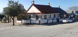 a white car parked in front of a building at Vuyomat Guest House 1 in Gqeberha