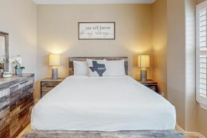 a bedroom with a large white bed with two lamps at Star Beachside Condominiums 106 in South Padre Island