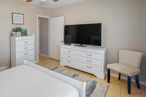 a bedroom with a bed and a television on a dresser at Star Beachside Condominiums 106 in South Padre Island