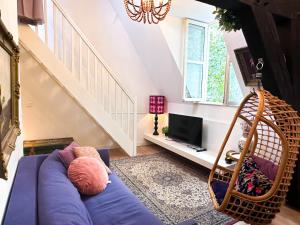 a living room with a blue couch and a swing at Gloria's loft op de Grote Markt in Breda