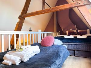 a room with two beds and towels on a mattress at Gloria's loft op de Grote Markt in Breda