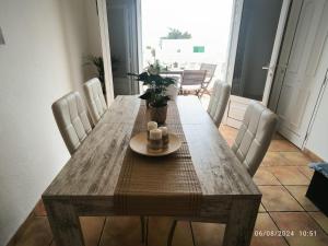 a dining room table with white chairs and a table with a plant at Casa Frasca in Teguise