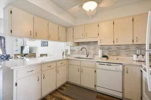 a kitchen with white cabinets and white appliances at Spanish Trace 243 in St. Augustine