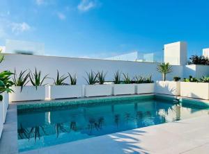 une piscine devant un mur blanc avec une piscine dans l'établissement Villa Kalma - Torreguadiaro - Sotogrande, à Sotogrande