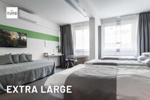 a hotel room with two beds and a desk at NunoHotel in Cologne