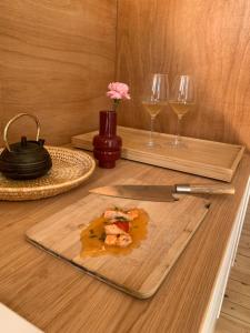 a cutting board with a knife and two glasses of wine at Maison du temps lent Centre historique en Arbois Escapade Romantique in Arbois +8 photos