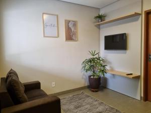 a living room with a couch and a tv on a wall at 1- ACHEI Casa - Seu espaço preferido em Porto Velho in Porto Velho