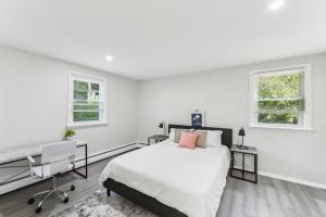 a white bedroom with a bed and a desk and two windows at Pine Brook 416 I Corporate 15Br Apartment ! Pool in Newark +12 photos