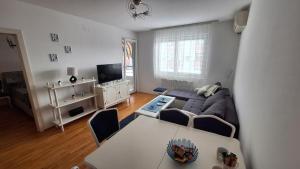 a living room with a blue couch and a table at Apartman Park in Šabac