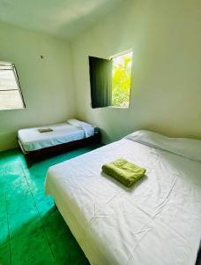 a bedroom with two beds and a window at Casa de las brujas hostal in Zipolite