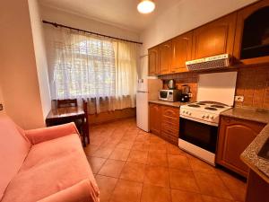 a kitchen with a couch and a stove top oven at Apartment Garden View in Tirana