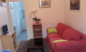 ムーランにあるL'appartement d'Aymarのリビングルーム(赤いソファ、テレビ付)