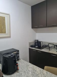 a kitchen with black cabinets and a counter top at Flat Pancetti in Belo Horizonte +48 photos