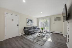 a living room with a couch and a table at Pine Brook 120 I Pool Gym I Free Parking ! in Newark