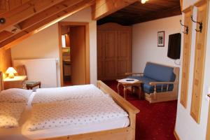 een slaapkamer met een bed, een bank en een tv bij Himmelbauer Apartments in Söbriach