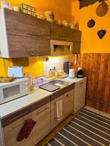 a kitchen with a sink and a microwave at Garan Vendégház in Jósvafő