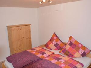 a room with a bed with pillows on it at Ferienhof Schönmetzler in Altusried